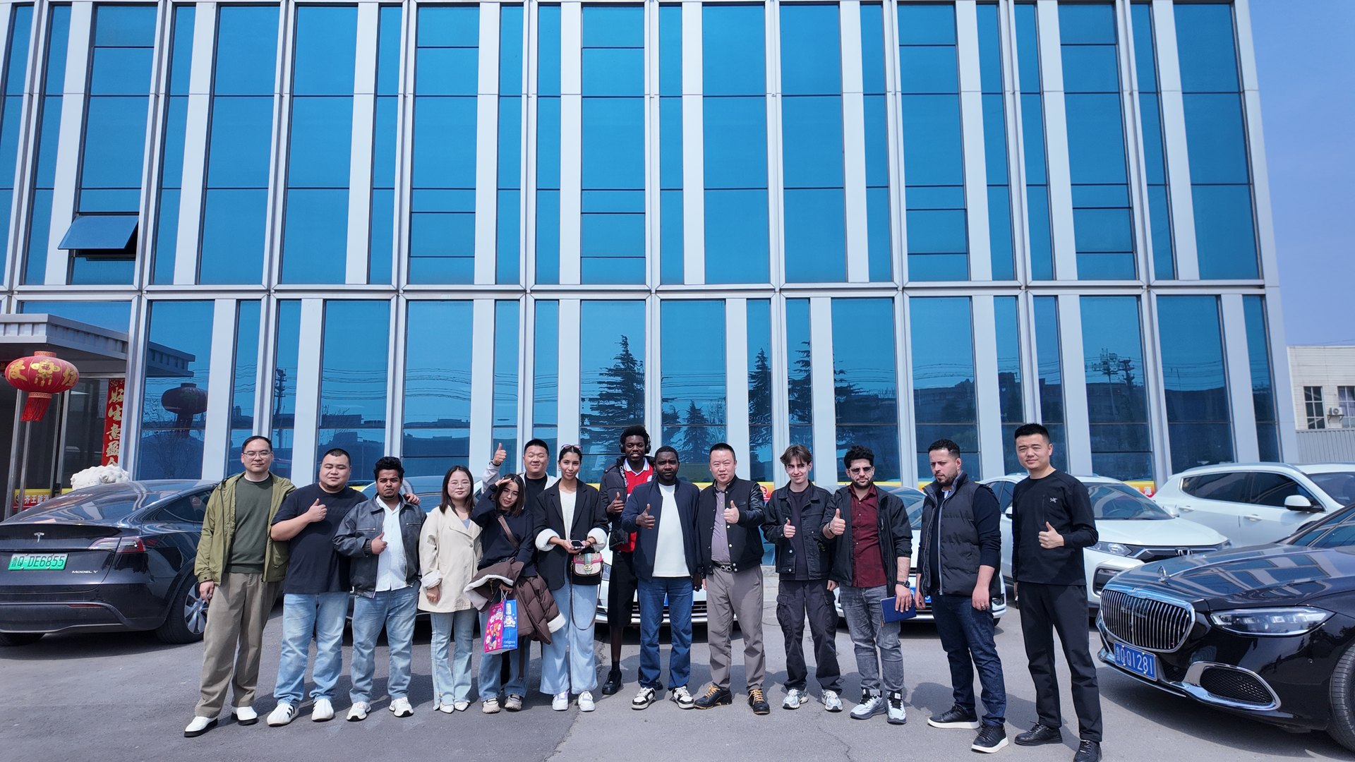 The Qi Wang Lithium Battery building in Linyi, Shandong, with a visiting group outside
